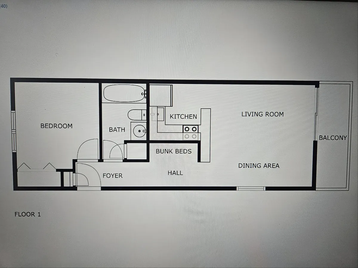A wide-angled view connecting the kitchen, dining area, living room, balcony, and bunk beds. This open space highlights the flow between cooking, dining, and relaxing while suggesting views of the ocean through the adjacent balcony.